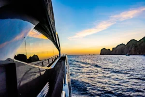 Beautiful photo of the side of our 80 foot Sunseeker Manhattan yacht in Cabo San Lucas, Mexico as the sun sets in the background